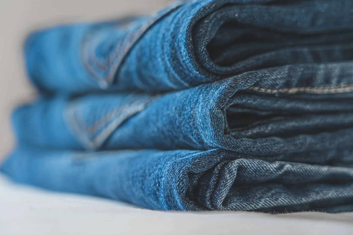 Folded blue denim jeans showing the fabric and seams