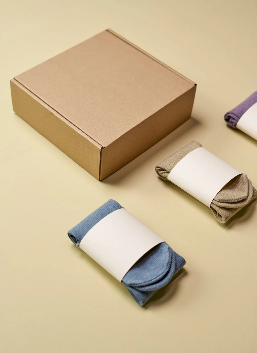 Several pairs of socks arranged beside their packaging