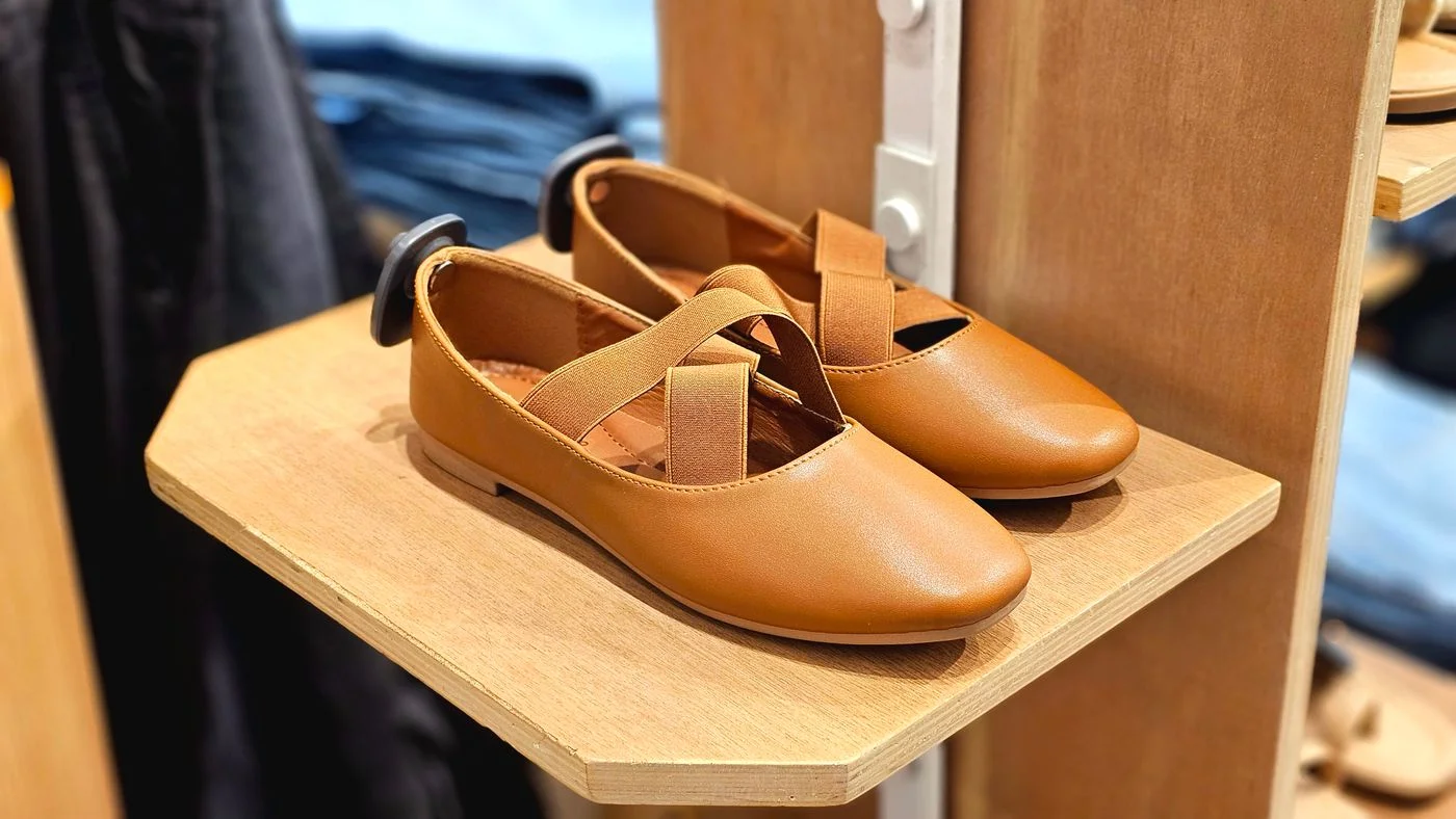 Brown ballet flats displayed on a shelf