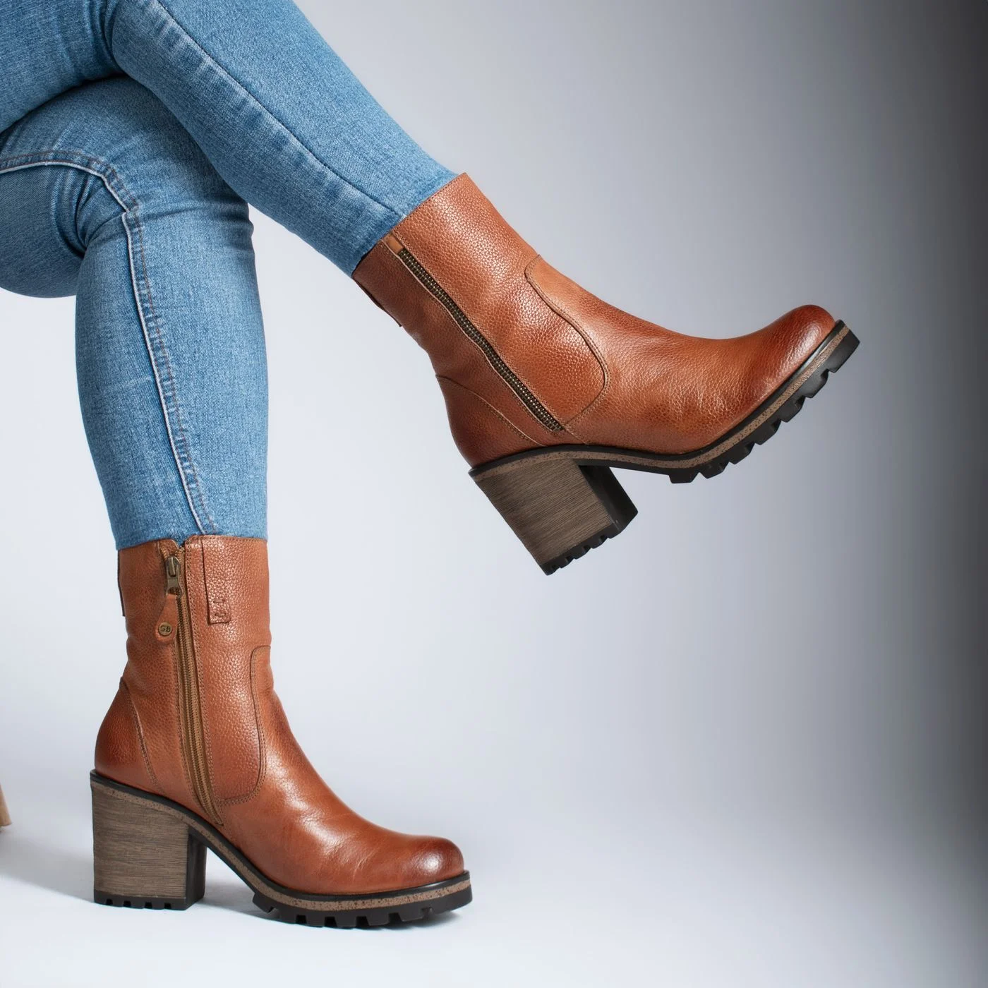 Close-up of Legs in Jeans and Brown Leather Ankle Boots with a Side Zipper