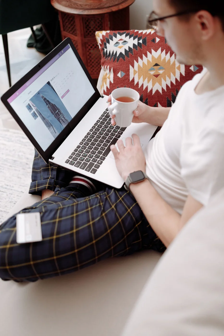 Person comparing an online purchase using a laptop at home