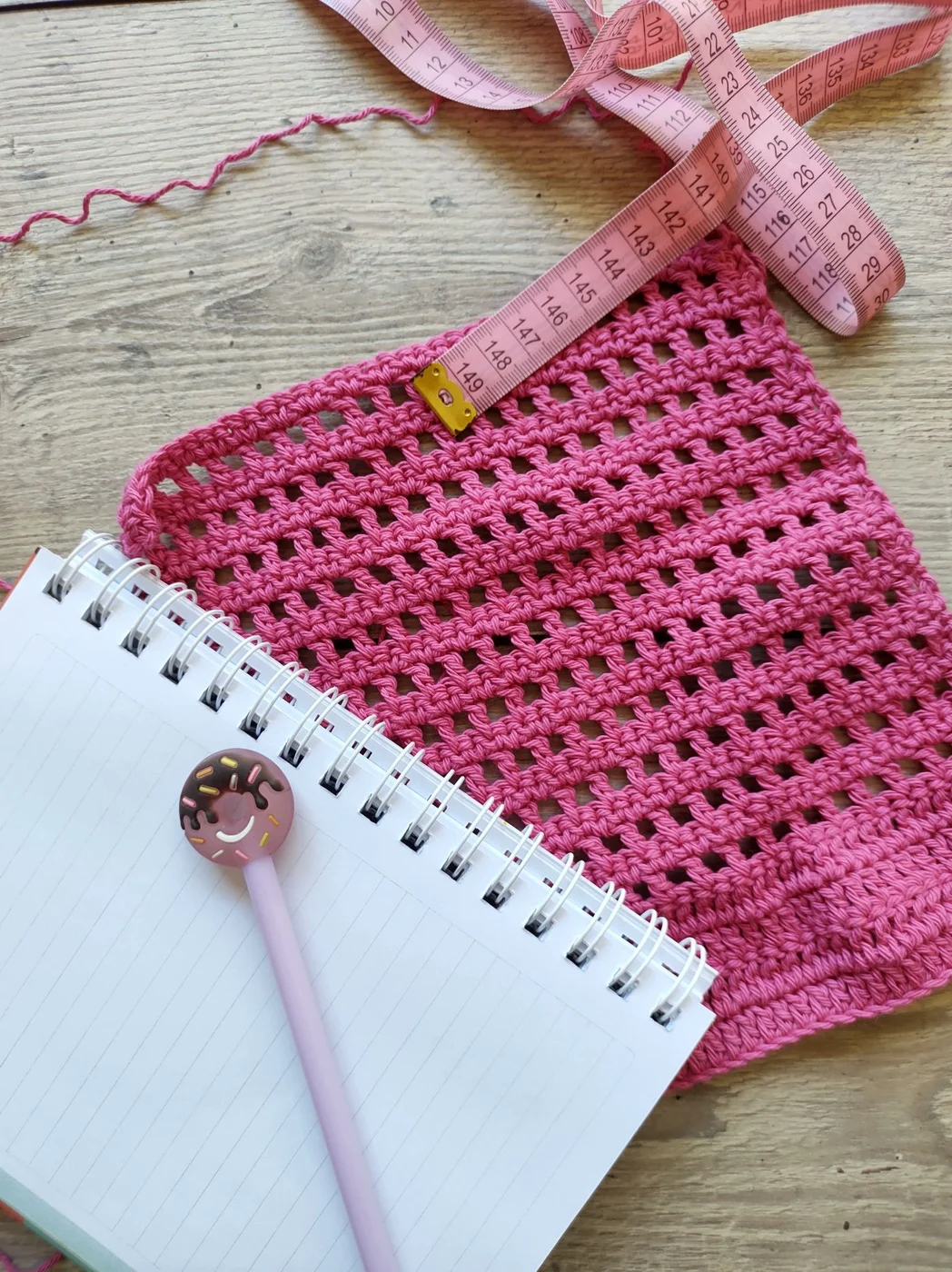 Notebook beside fabric and a measuring tape